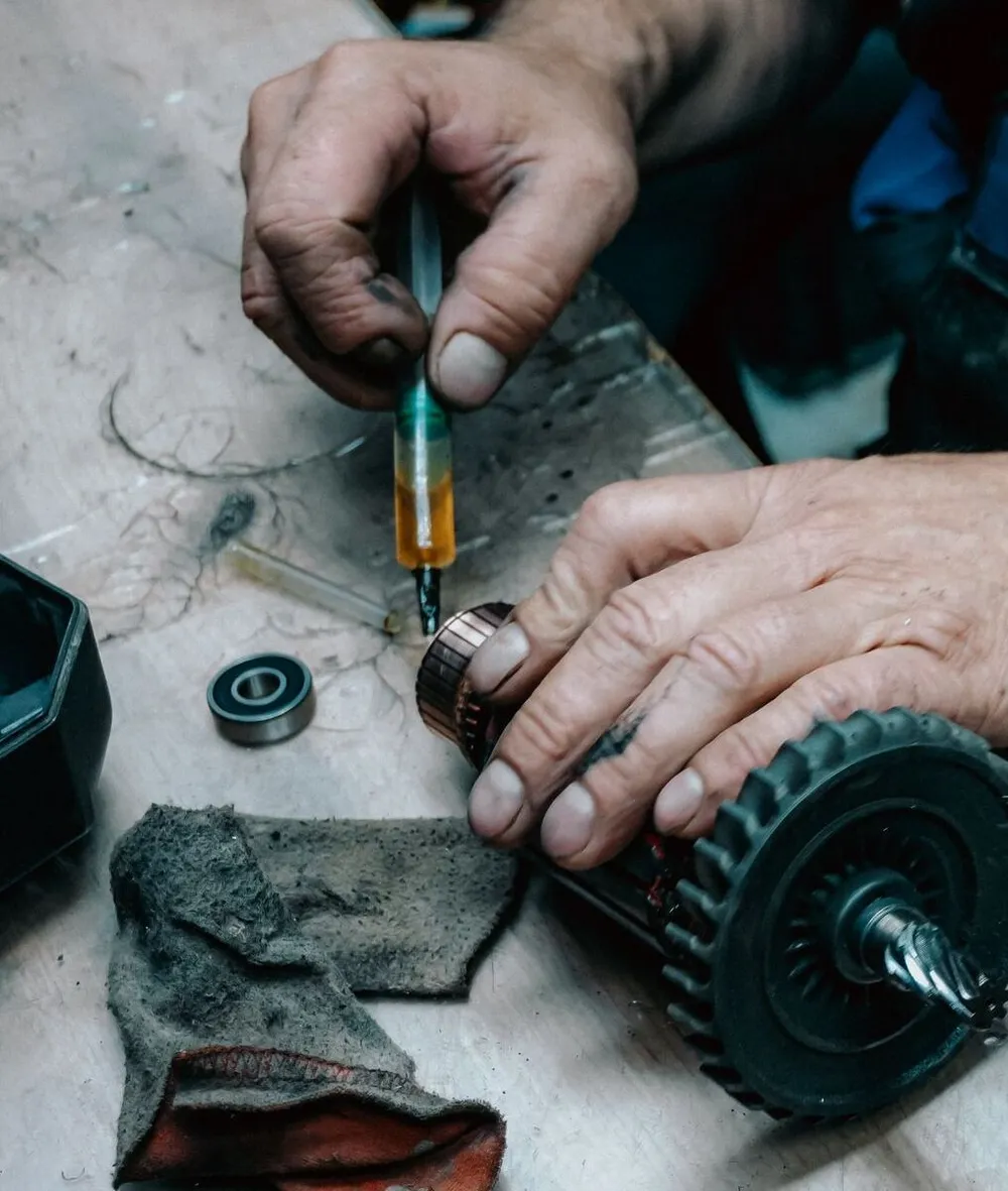 Technician applying lubricant to a gear assembly with a syringe